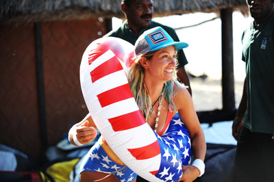 woman with patriotic hat wearing an American flag floatie and smiling